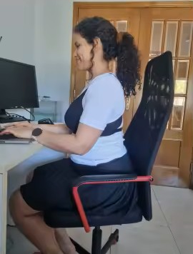Mujer usando el corrector de postura NÜMA mientras trabaja en su escritorio